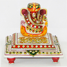 Marble ganesh idol sporting a turban and sitting on chowki